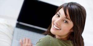 Attractive young female using a laptop Portrait of a happy young female using a laptop